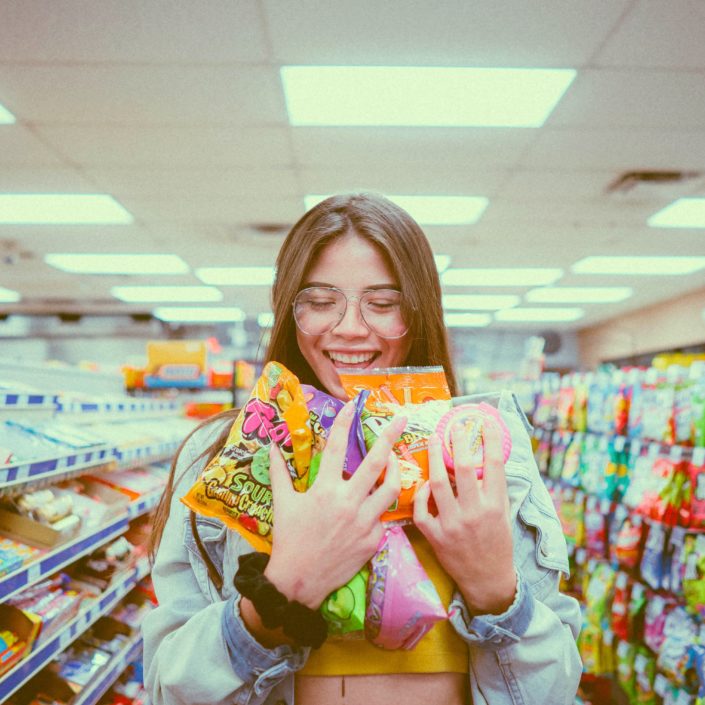 Girl wearing glasses, holding shopping in a supermarket