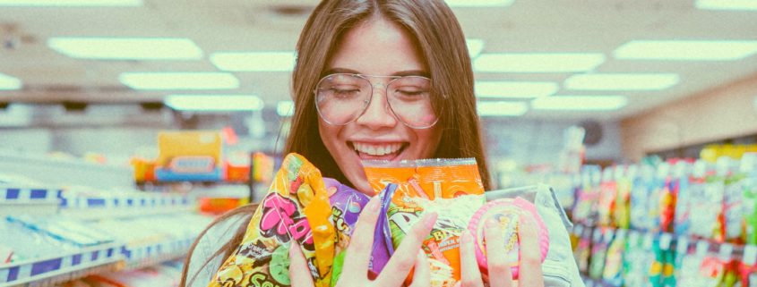 Girl wearing glasses, holding shopping in a supermarket