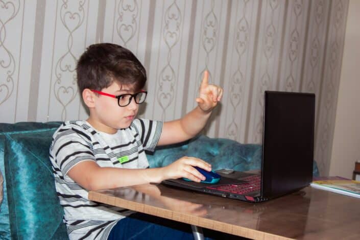 child wearing glasses using laptop