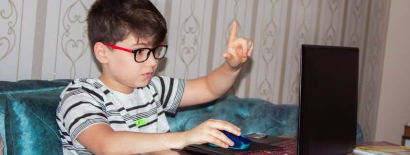 child wearing glasses using laptop